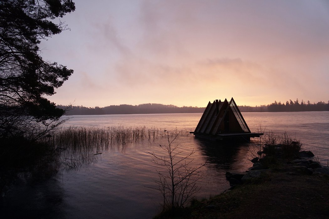 A triangular floating sauna in the evening light
