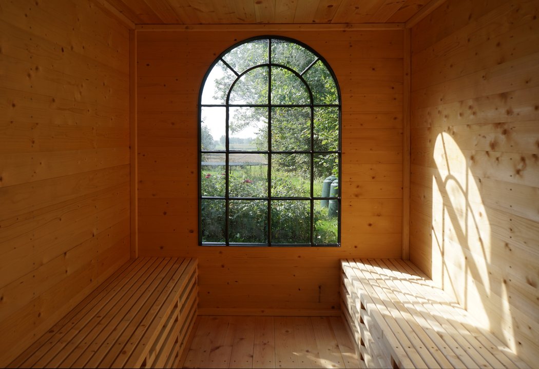 Inside sauna with a big arched window